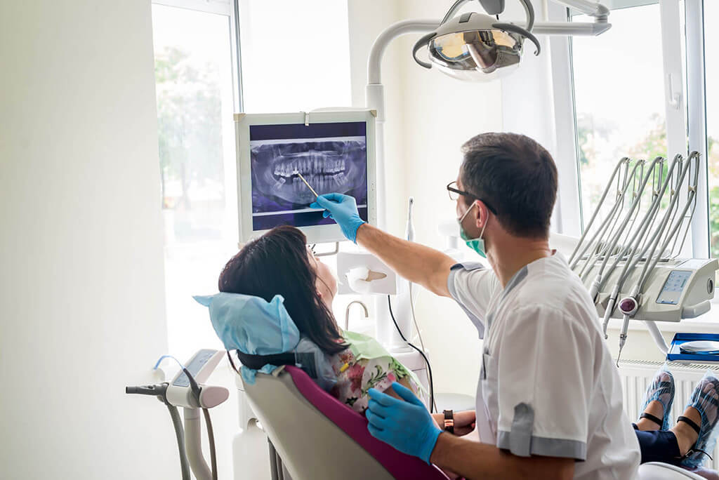 Zahnarzt, der ein Röntgenbild erklärt